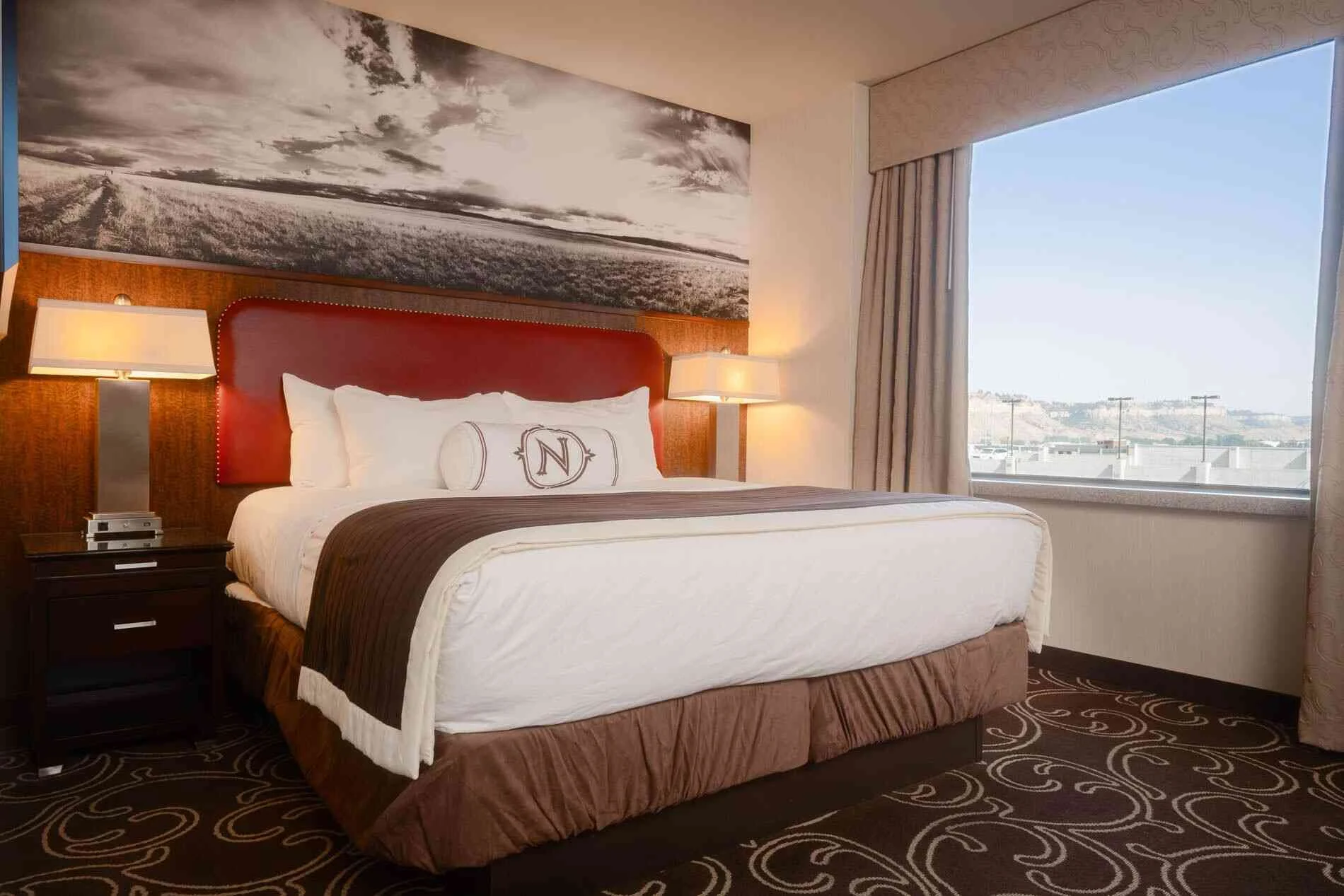 Boutique hotel room with hardwood accents, soft lighting, and downtown Billings views